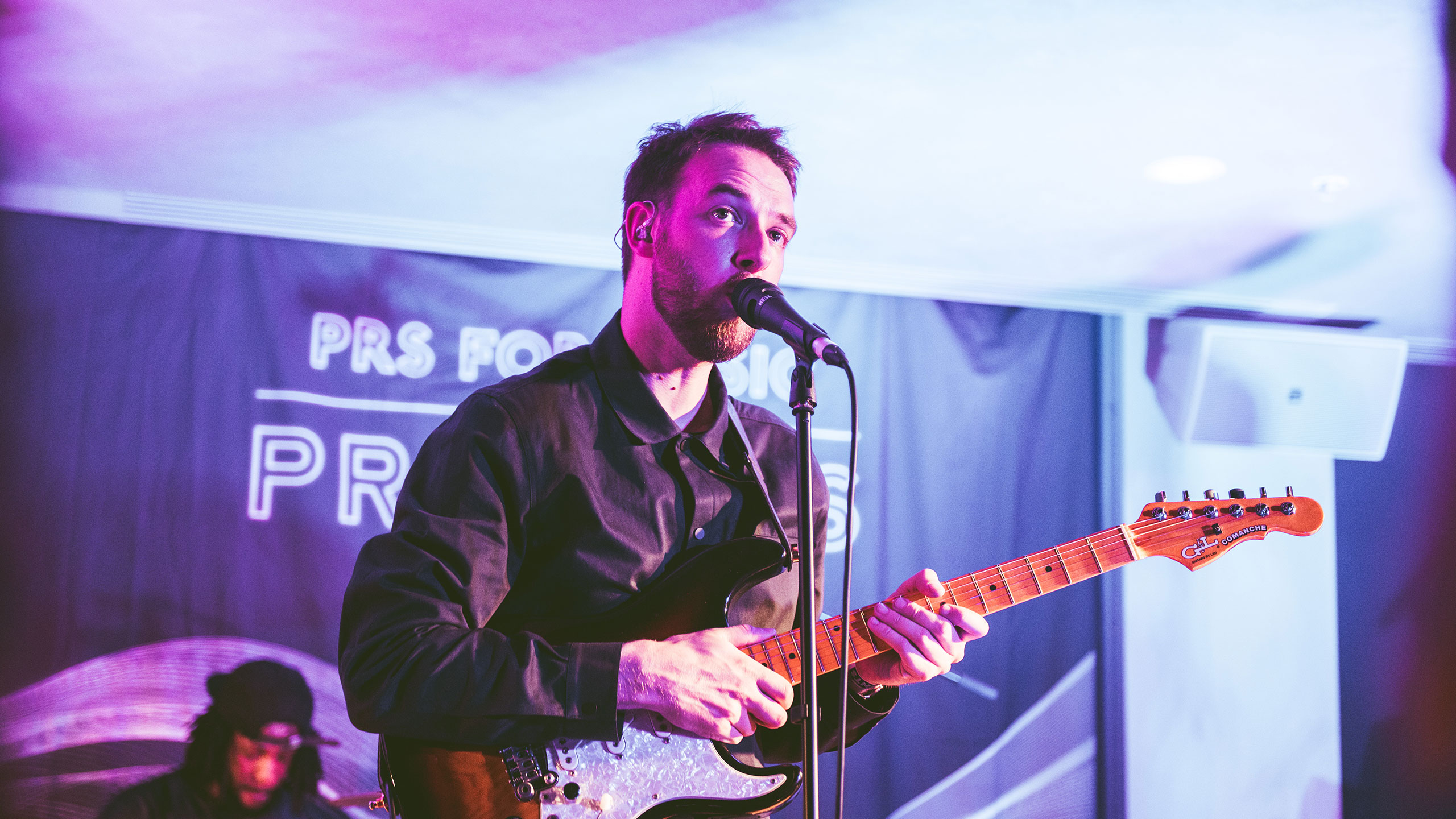 Honne's Andy Clutterbuck plays guitar and sings at PRS Presents, wearing a dark shirt