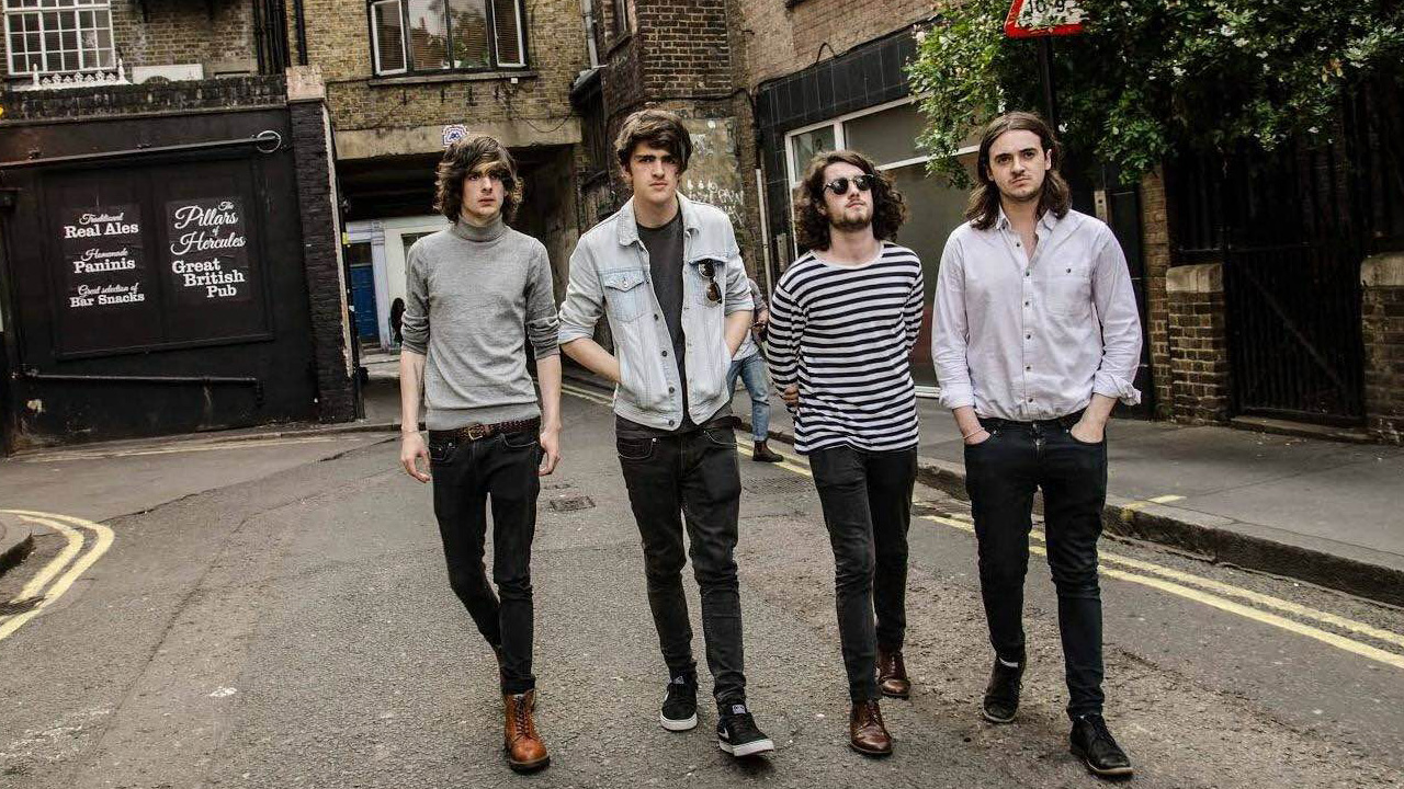 Four-piece band, The Clameens walk down a street wearing casual clothing