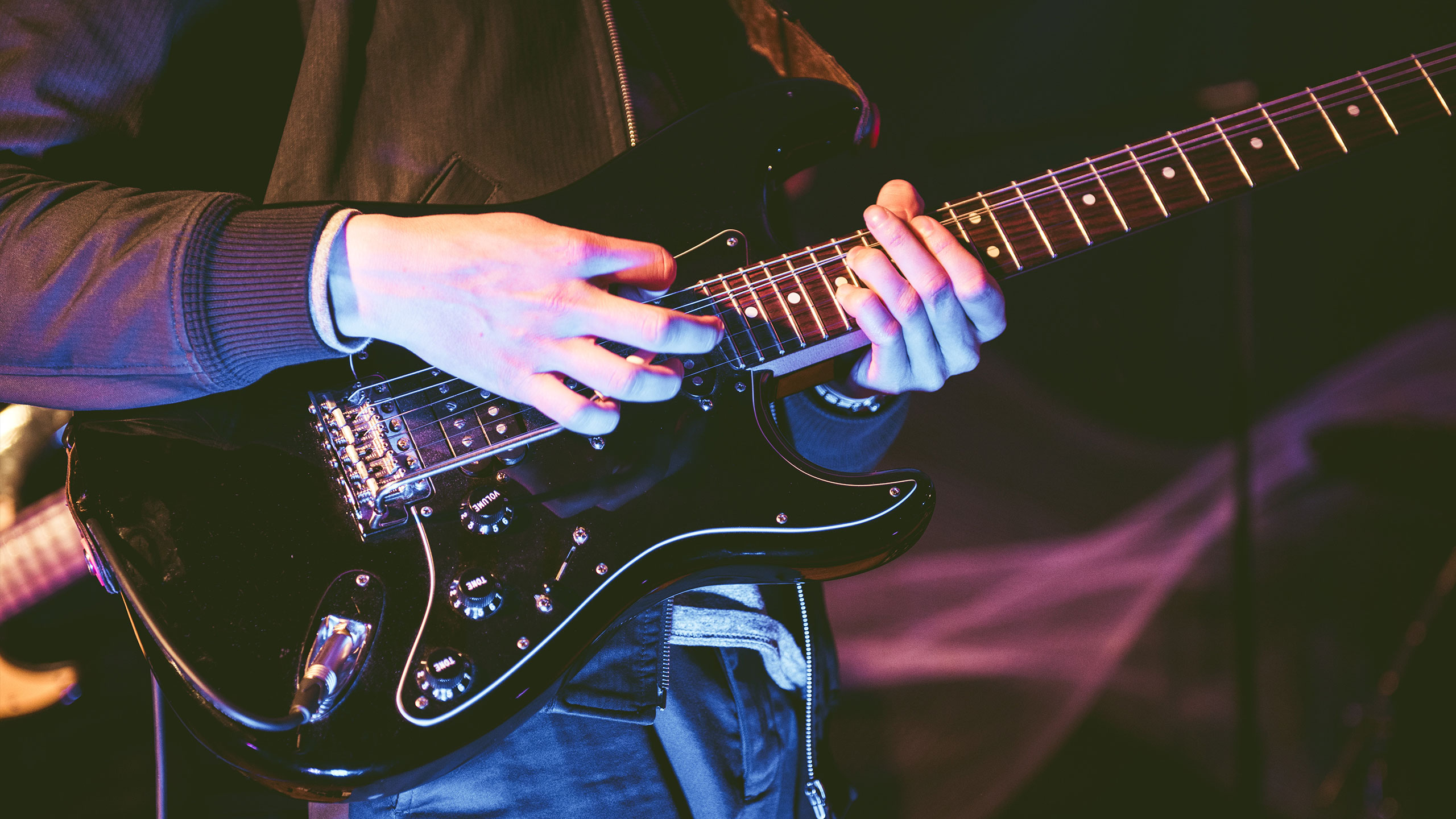 A close up photo Honne's James Hatcher's black guitar
