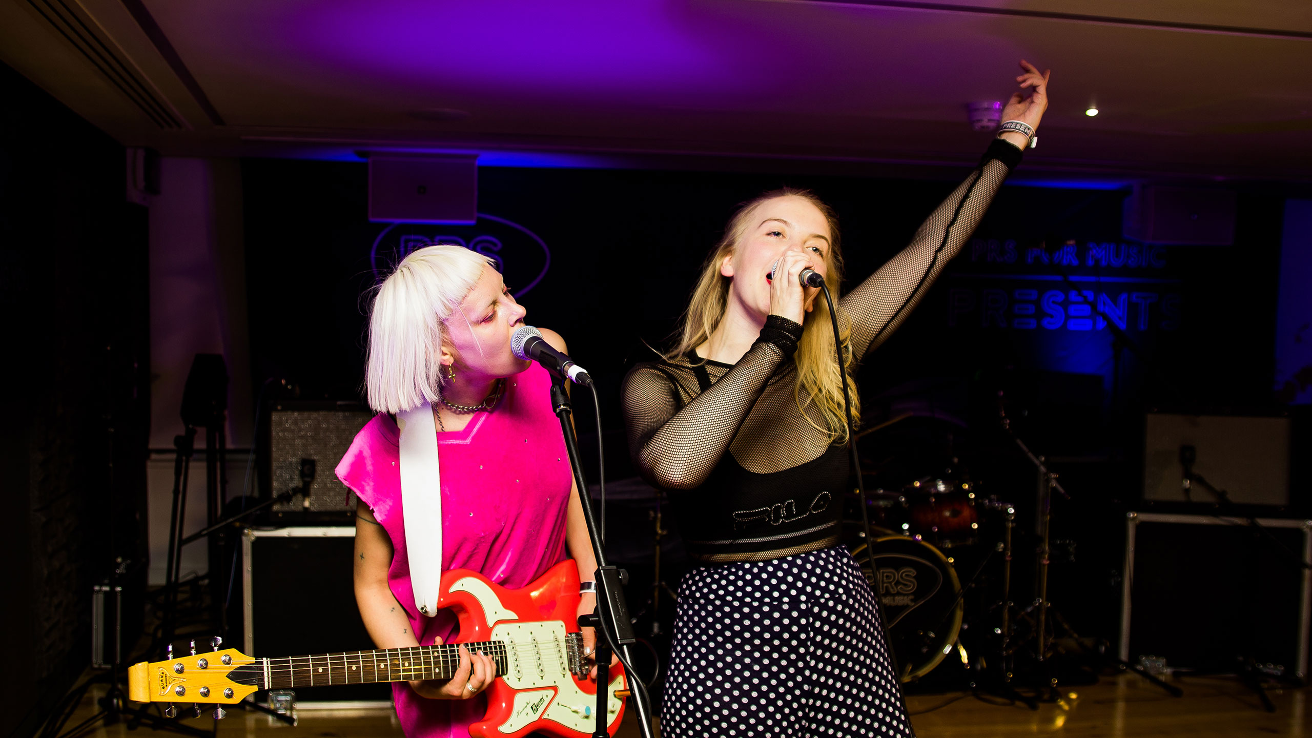 Dream Wife's Rakel Mjoll and Alice Go sing into the microphones on stage at PRS for music Presents