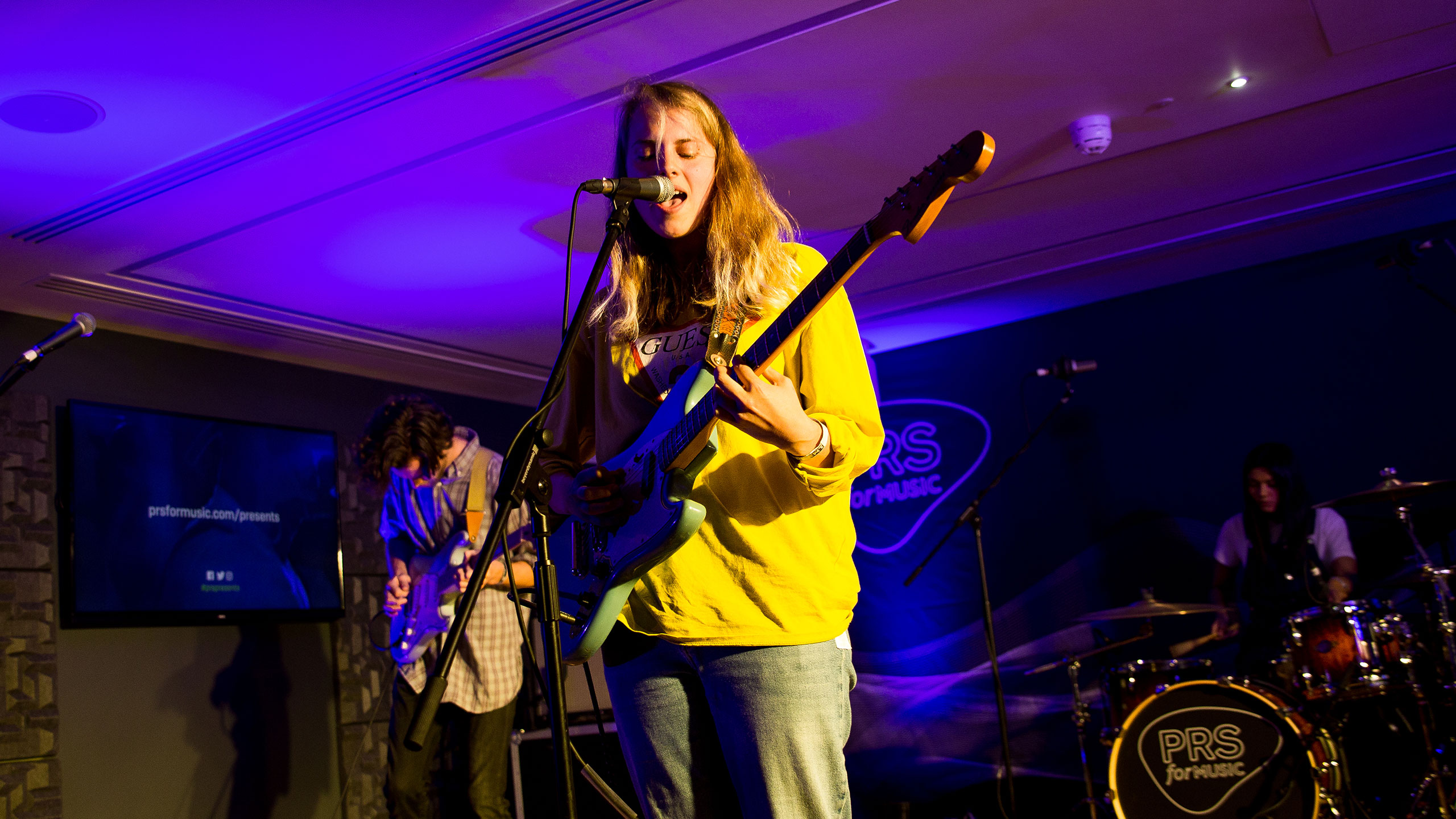 Marika Hackman, wearing a yellow shirt, performing at PRS for Music Presents