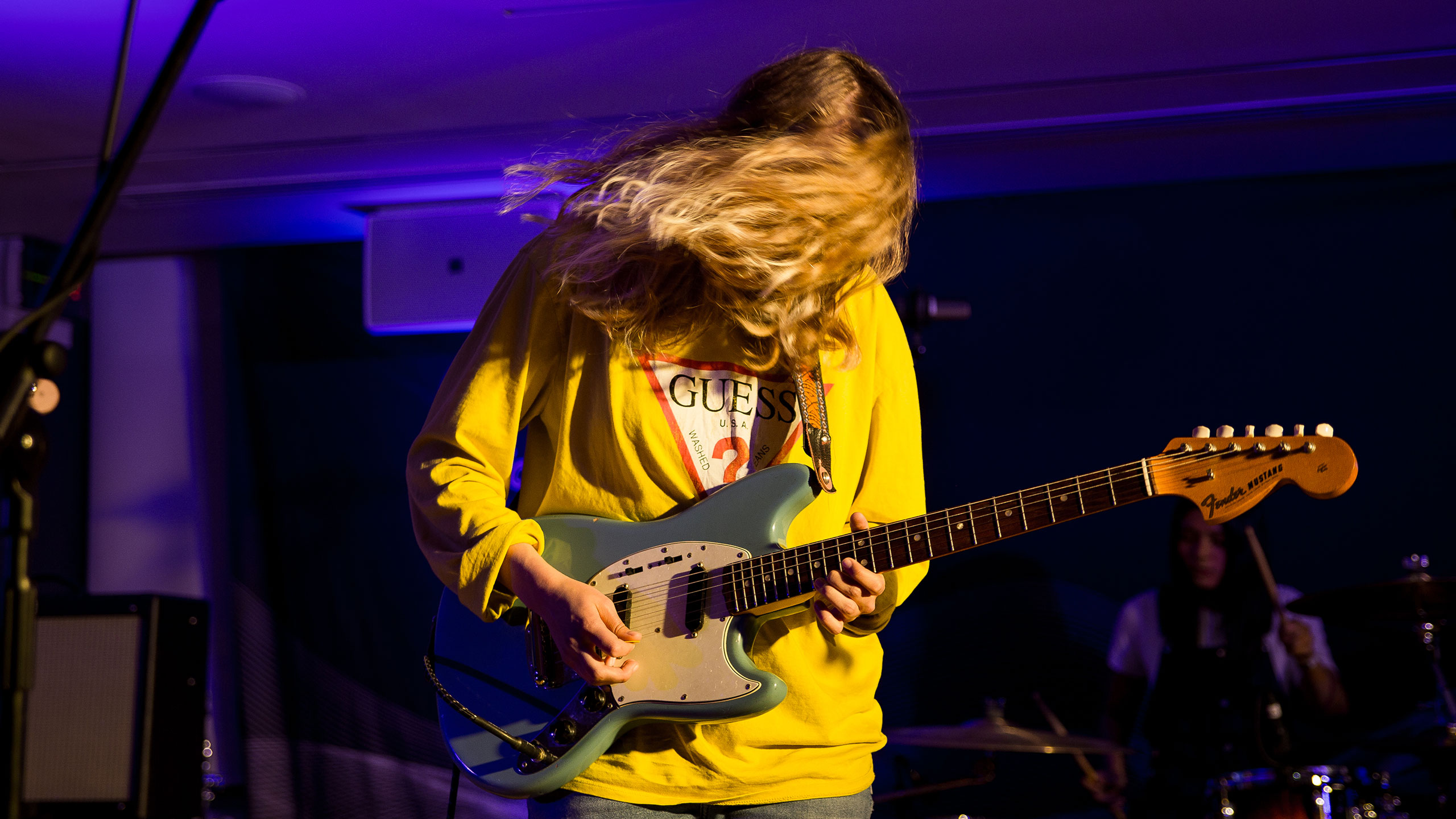 Marika Hackman swings her hair in front of her face as she plays guitar on stage at PRS for Music Presents
