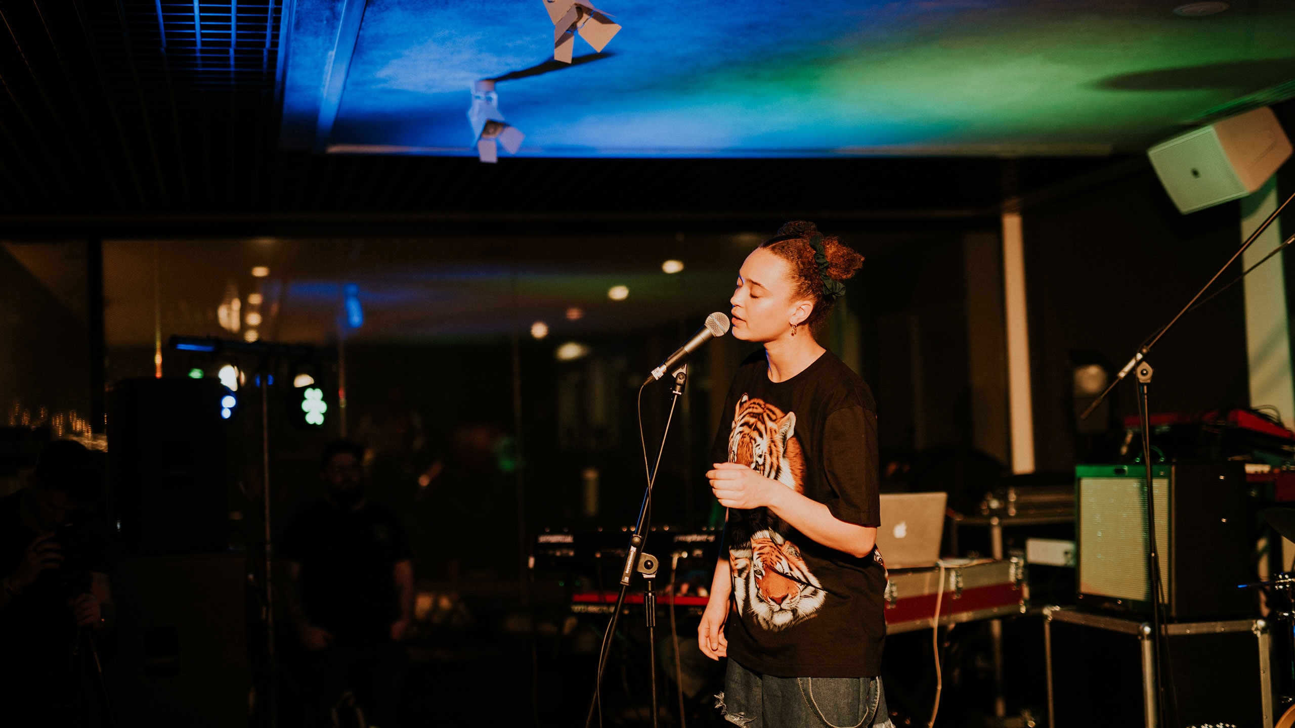 Connie Constance, wearing a t shirt with a tiger on it, sings at PRS for Music Presents