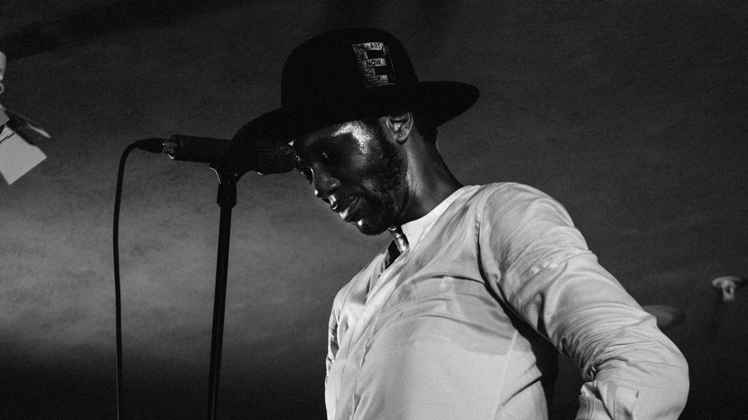 Baloji in a white shirt and wide-rimmed black hat at PRS for Music Presents
