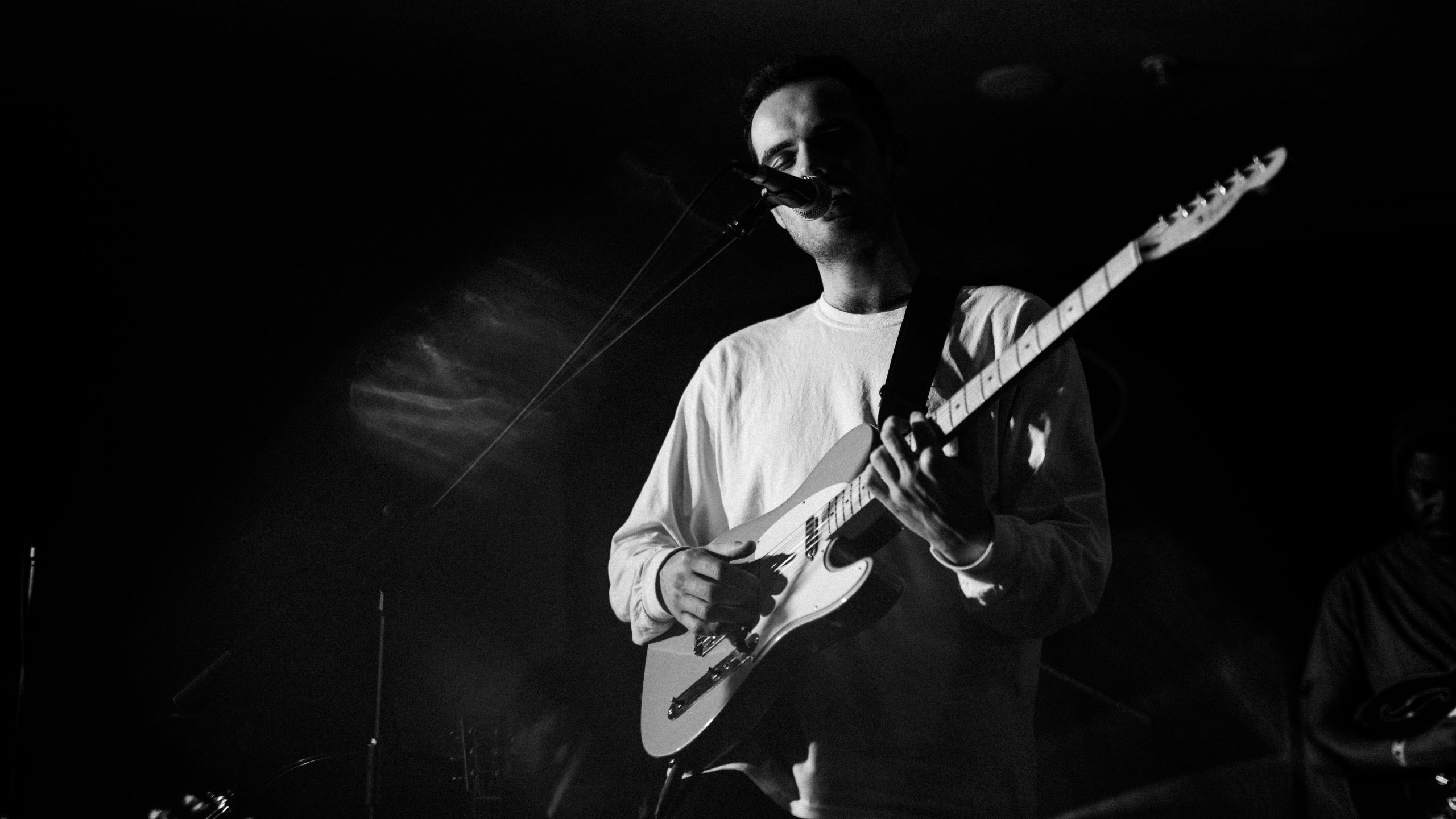 Jordan Rakei in a white sweatshirt plays guitar and sings at PRS for Music Presents