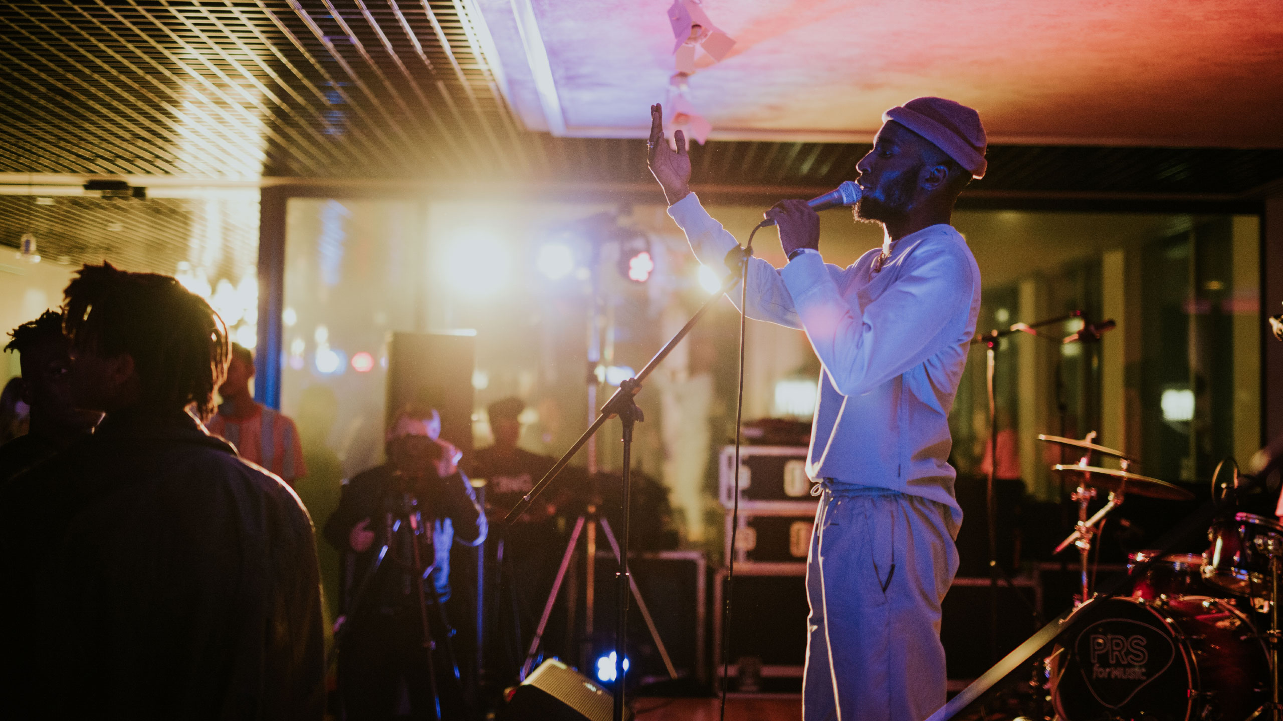 Kojey Radical reaching an arm out as he sings at PRS for Music Presents