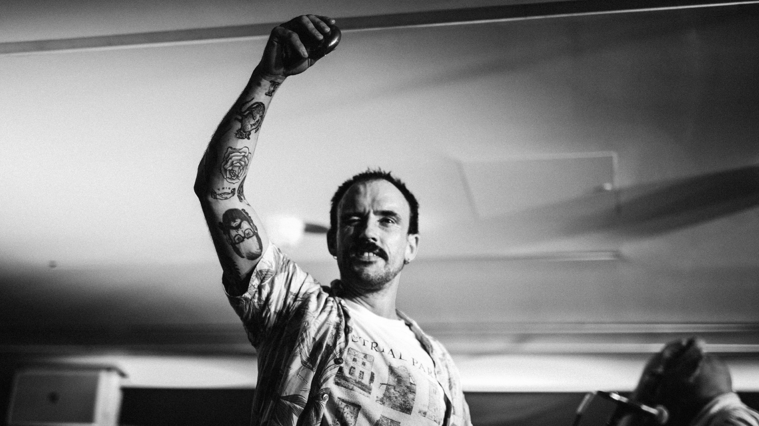 Idles frontman Joe Talbot raising his right arm on stage at PRS for Music Presents