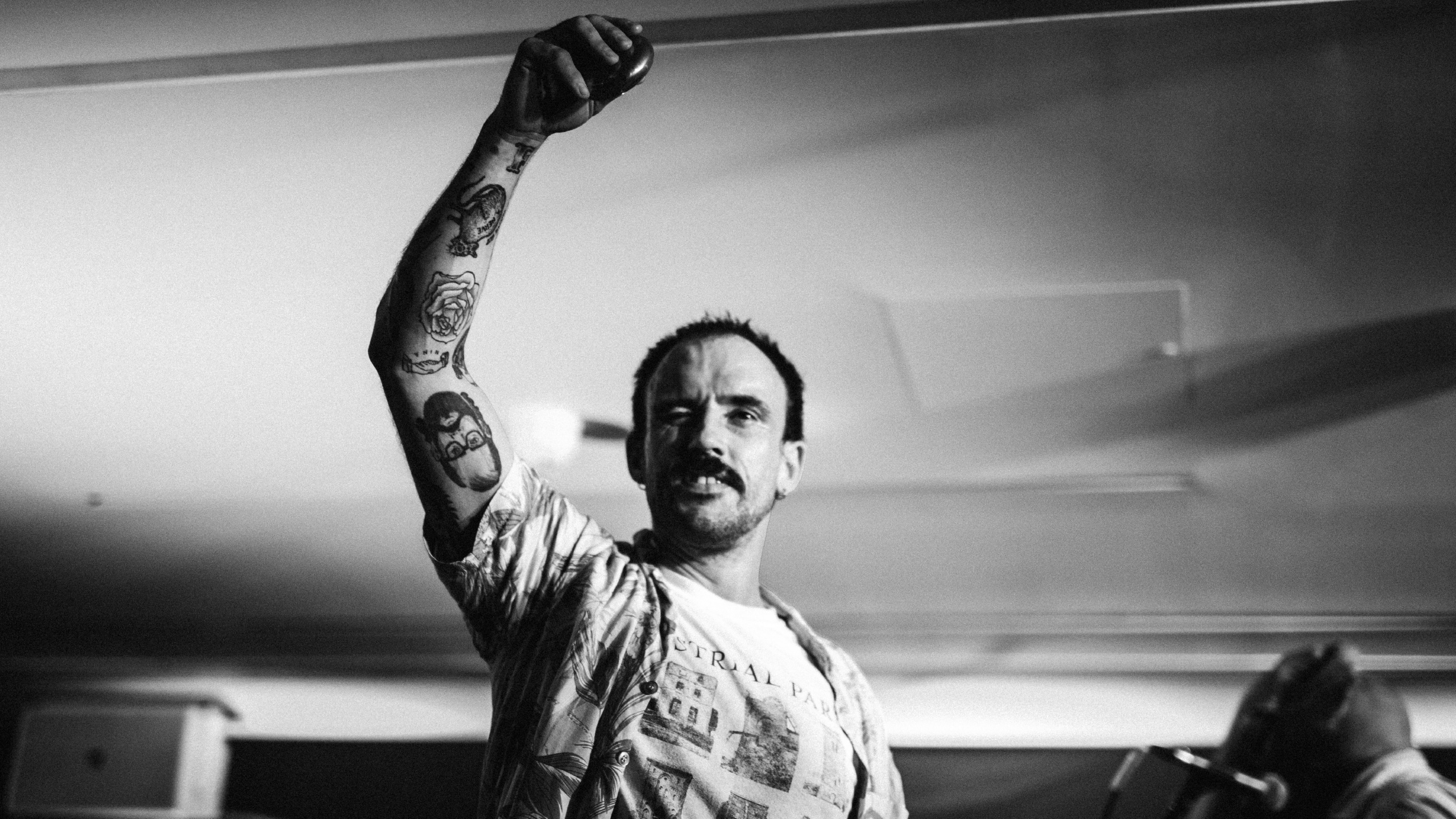 Idles frontman Joe Talbot raising his right arm on stage at PRS for Music Presents
