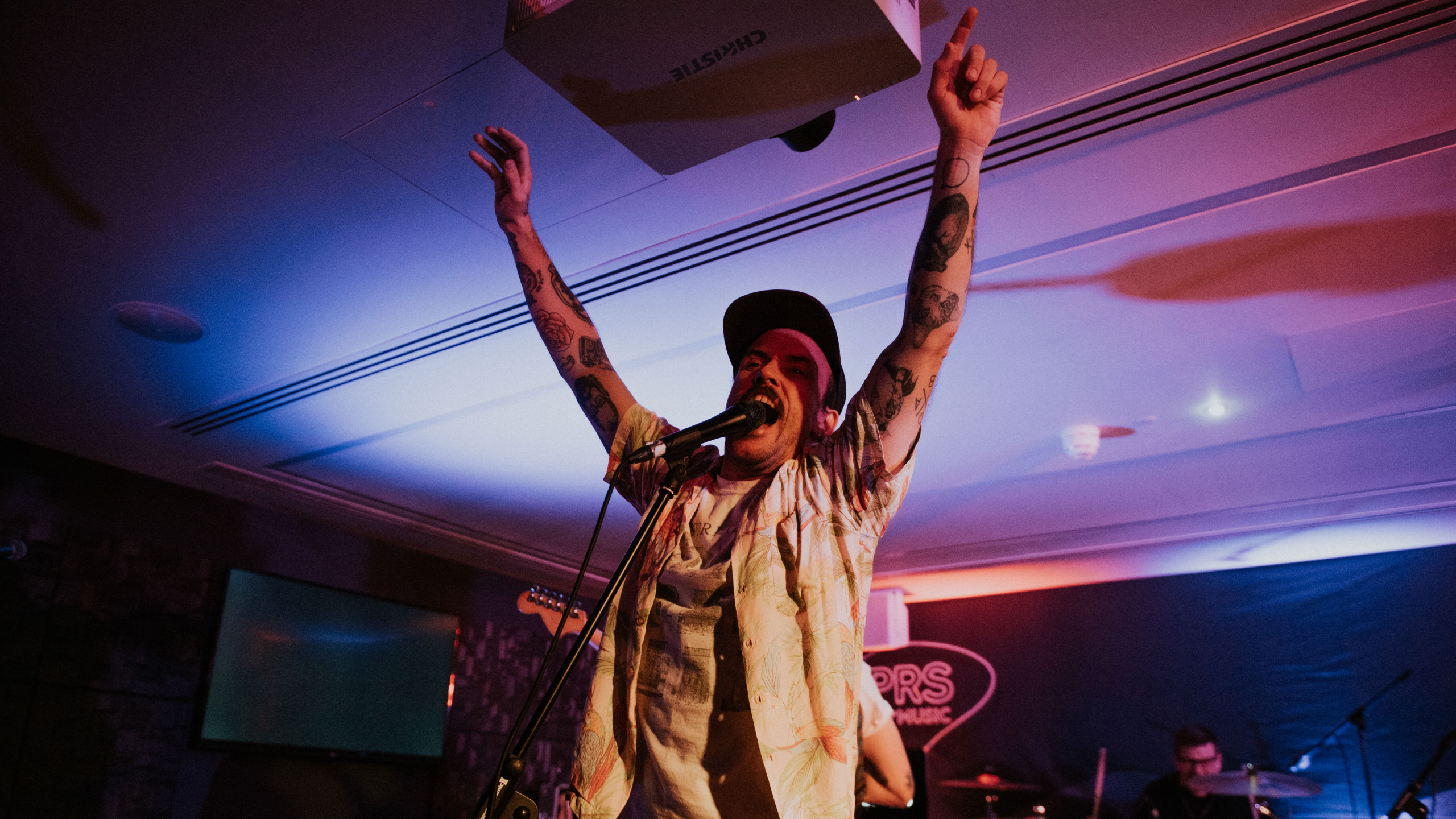 Idles frontman Joe Talbot raising his clenched fists on stage at PRS for Music Presents